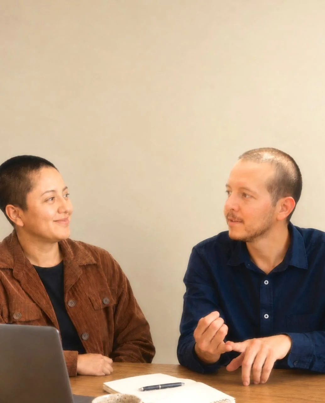 Sofía y Pablo conversando sobre una mesa de trabajo